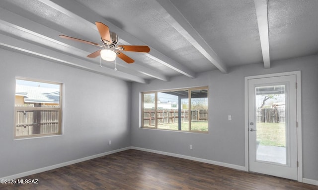 unfurnished room featuring a textured ceiling, baseboards, dark wood finished floors, and beam ceiling