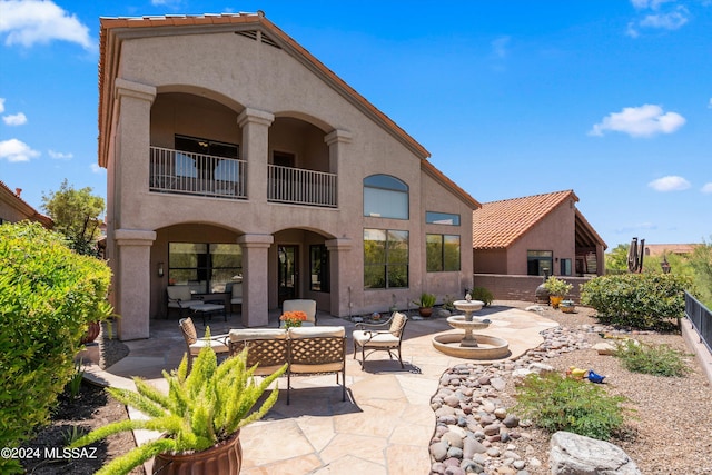 rear view of house with outdoor lounge area and a patio