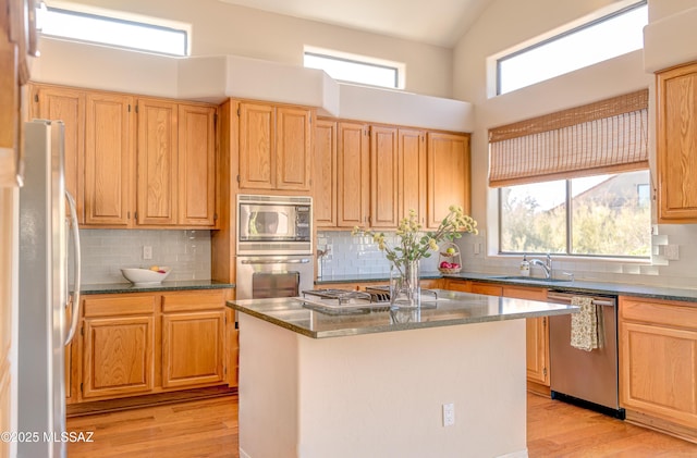 kitchen featuring a kitchen island, sink, a healthy amount of sunlight, and stainless steel appliances