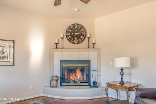 details featuring wood-type flooring, ceiling fan, and a tiled fireplace