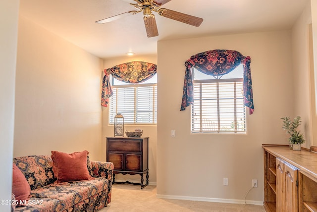 sitting room with ceiling fan and light carpet