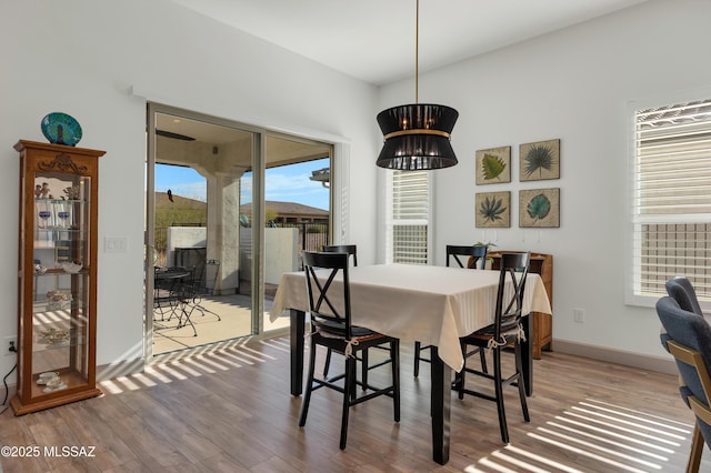 dining area with hardwood / wood-style flooring and a notable chandelier