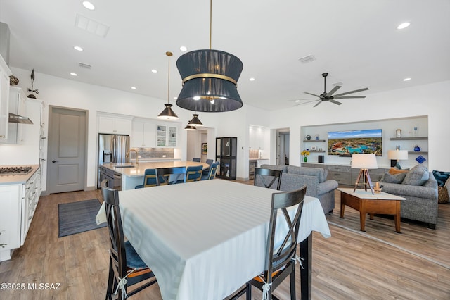 dining area featuring sink, ceiling fan, and light hardwood / wood-style flooring