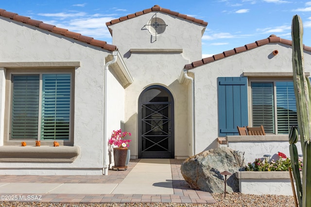 view of exterior entry with a patio