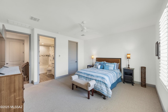 bedroom featuring ceiling fan, connected bathroom, and light carpet