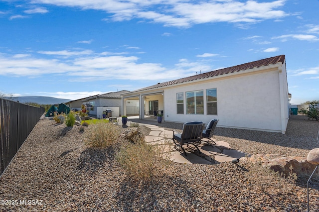 rear view of house featuring a mountain view and a patio area