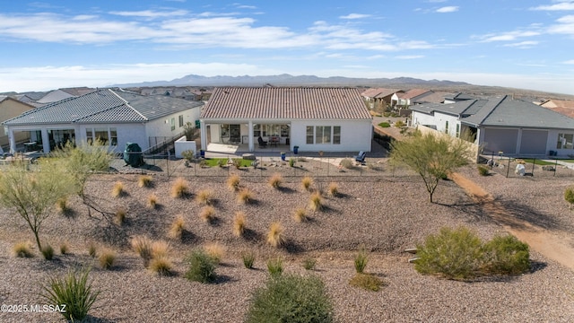 rear view of property with a mountain view and a patio area