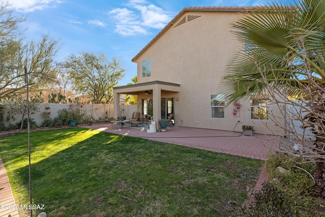 back of property featuring a lawn, ceiling fan, and a patio