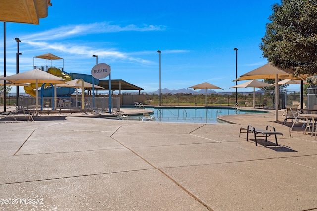 view of swimming pool with a mountain view and a patio