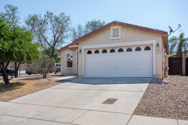 view of front facade featuring stucco siding, concrete driveway, and a garage