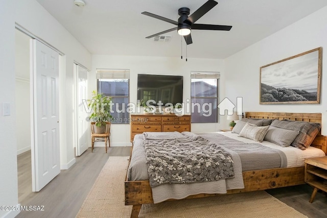 bedroom featuring multiple windows, ceiling fan, and light hardwood / wood-style floors