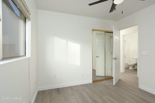 unfurnished bedroom featuring ensuite bath, ceiling fan, a closet, and light hardwood / wood-style flooring