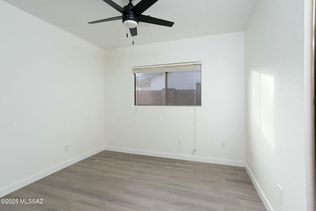 spare room with baseboards, light wood-type flooring, and ceiling fan