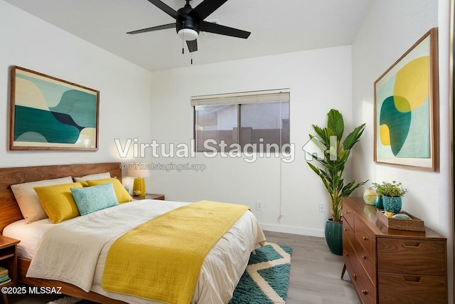 bedroom with a ceiling fan, wood finished floors, and baseboards