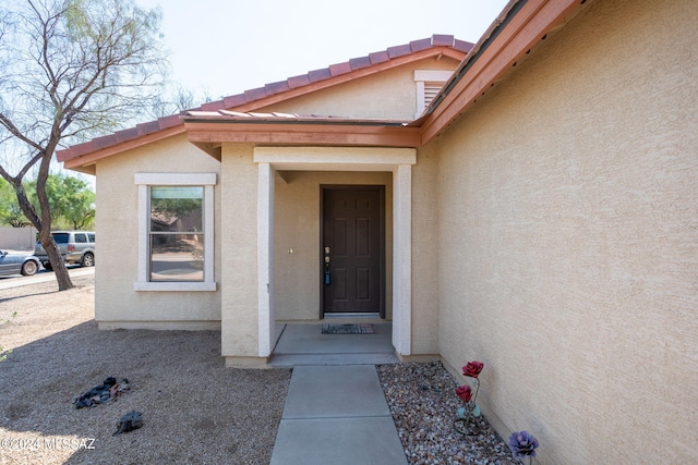 doorway to property featuring stucco siding