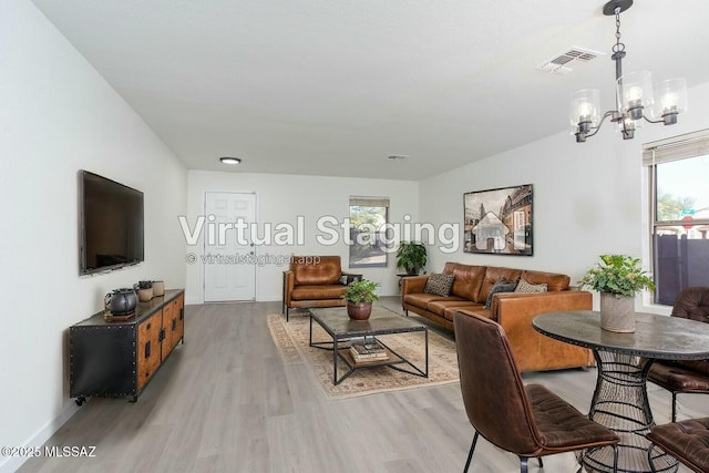 living room featuring a healthy amount of sunlight, a notable chandelier, and hardwood / wood-style flooring