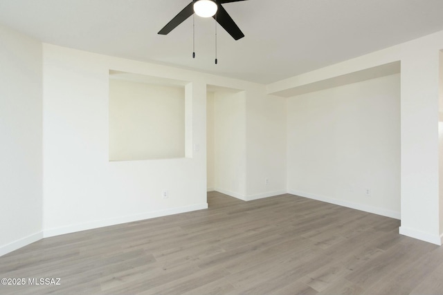 empty room with baseboards, a ceiling fan, and wood finished floors