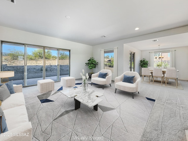 living room with an inviting chandelier and light carpet