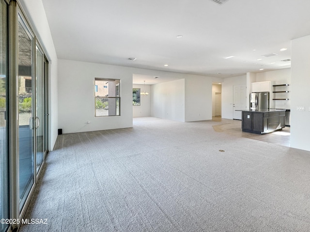 8015 S Galileo Ln, Tucson, AZ 85747 - unfurnished living room featuring light carpet, an inviting chandelier, and recessed lighting