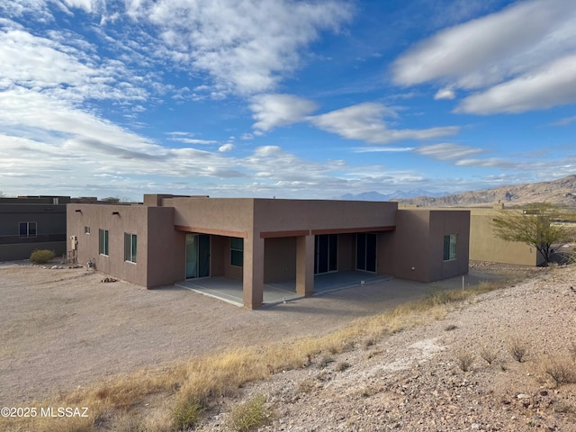 back of house featuring a mountain view and a patio