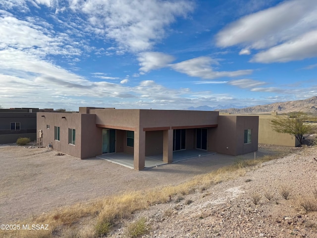 8015 S Galileo Ln, Tucson, AZ 85747 - rear view of property featuring stucco siding, a mountain view, and a patio area