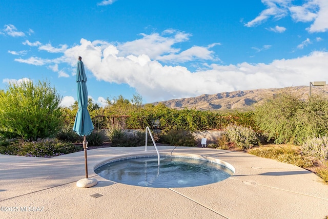 view of pool with a mountain view, a patio area, and an in ground hot tub