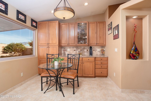 tiled dining room featuring vaulted ceiling