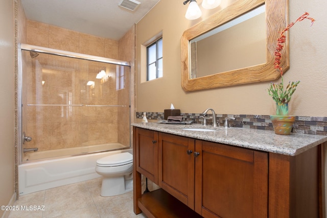 full bathroom featuring tile patterned floors, toilet, combined bath / shower with glass door, and vanity