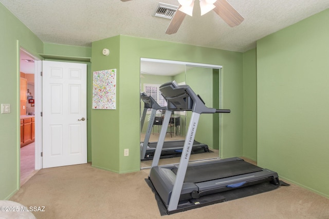 workout room with light carpet, a textured ceiling, and ceiling fan