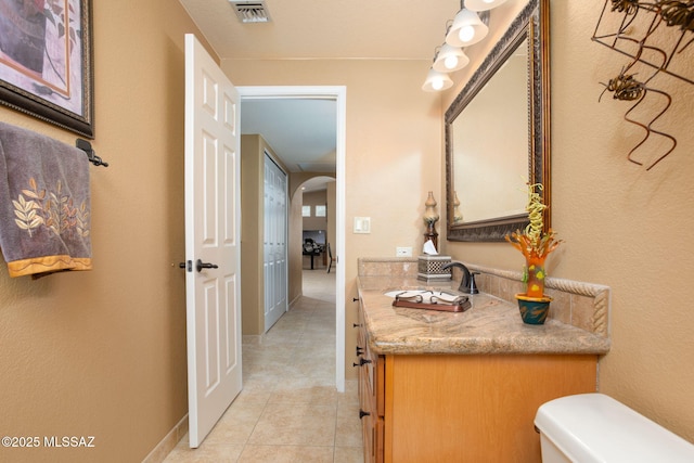 bathroom with tile patterned flooring, vanity, and toilet