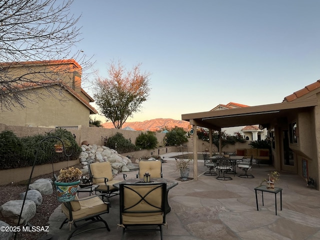 patio terrace at dusk featuring a mountain view