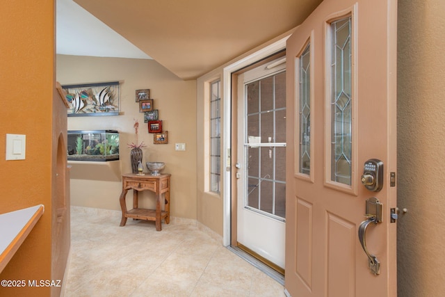 entryway featuring light tile patterned floors and lofted ceiling