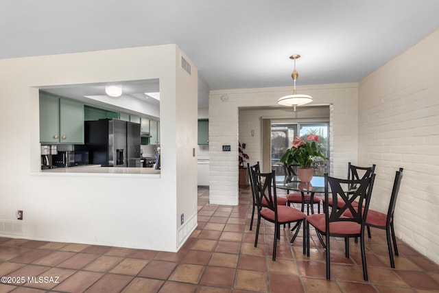 tiled dining area with brick wall