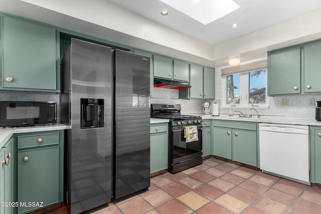 kitchen with a skylight, black appliances, and green cabinetry