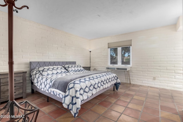 bedroom featuring brick wall