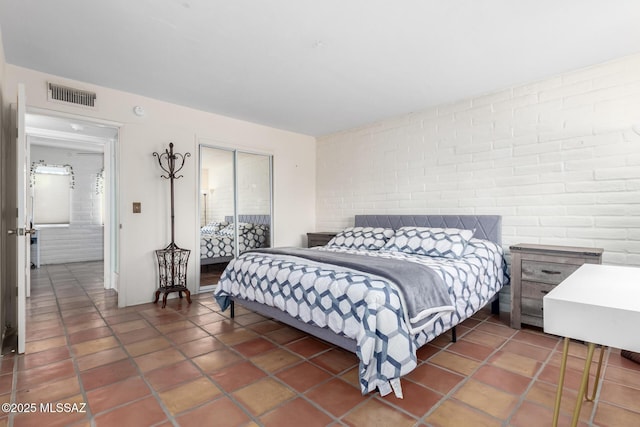 bedroom featuring brick wall