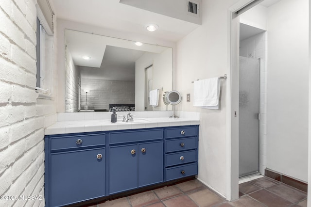 bathroom with a shower with door and vanity