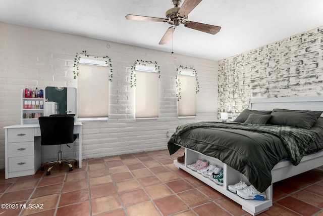 tiled bedroom with ceiling fan and brick wall