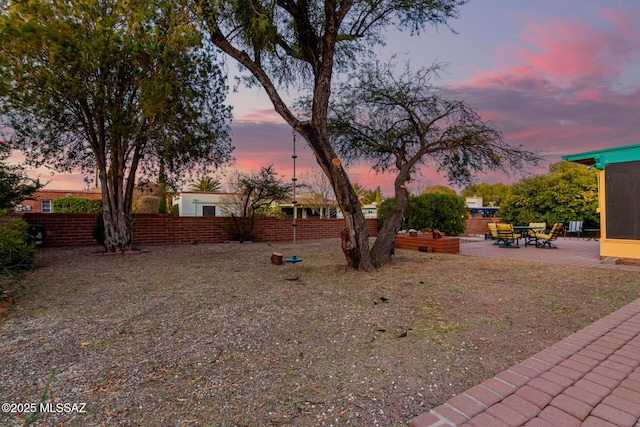 yard at dusk with a patio area