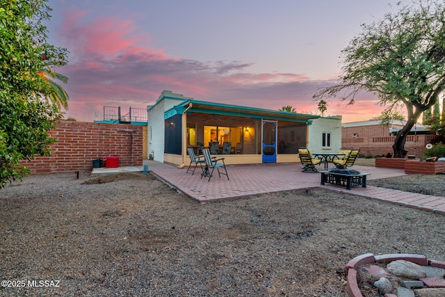 back house at dusk with a patio and an outdoor fire pit