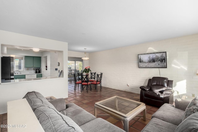 living room featuring sink and brick wall