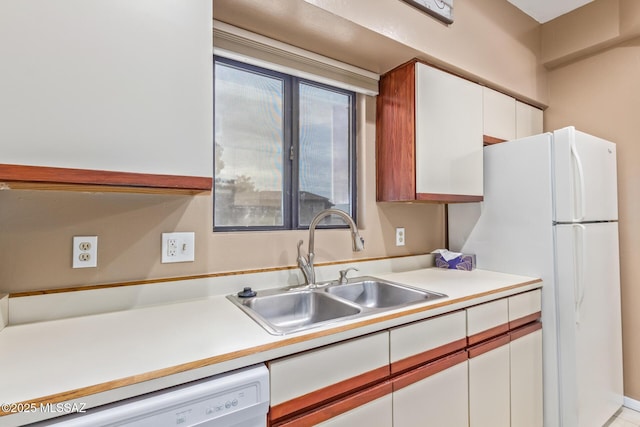 kitchen with white cabinetry, sink, and white appliances