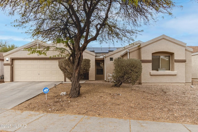 ranch-style home featuring solar panels and a garage