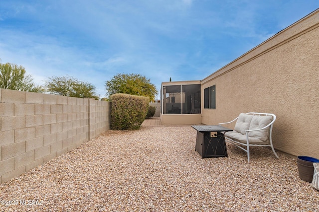 view of yard featuring a patio area, a sunroom, and an outdoor fire pit