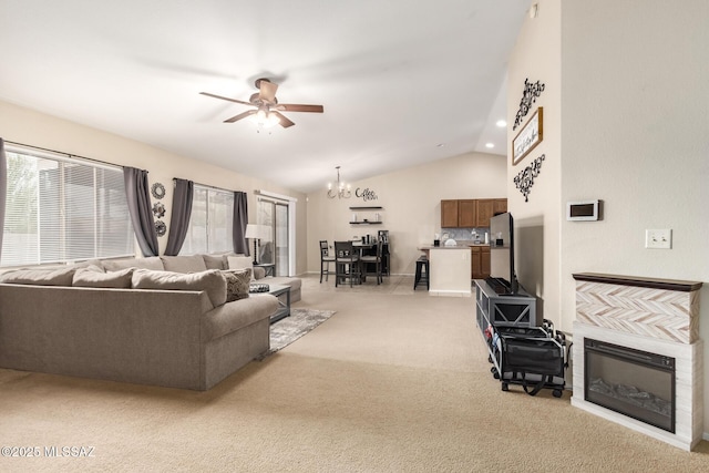 carpeted living room featuring ceiling fan with notable chandelier and lofted ceiling