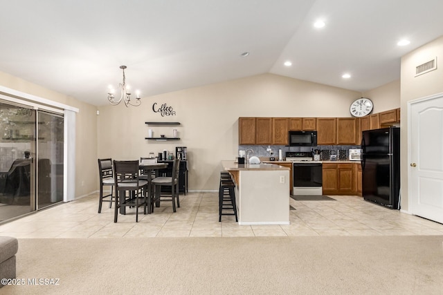 kitchen featuring black appliances, a kitchen island with sink, hanging light fixtures, and light carpet