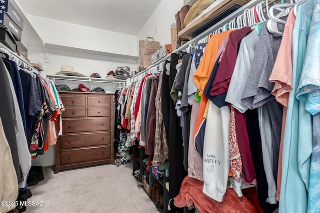 walk in closet featuring light colored carpet