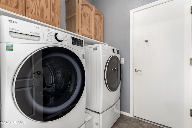 washroom with cabinets and washing machine and dryer