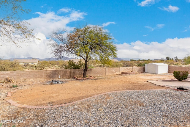 view of yard featuring a mountain view and a storage shed