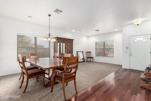 carpeted dining area featuring a notable chandelier